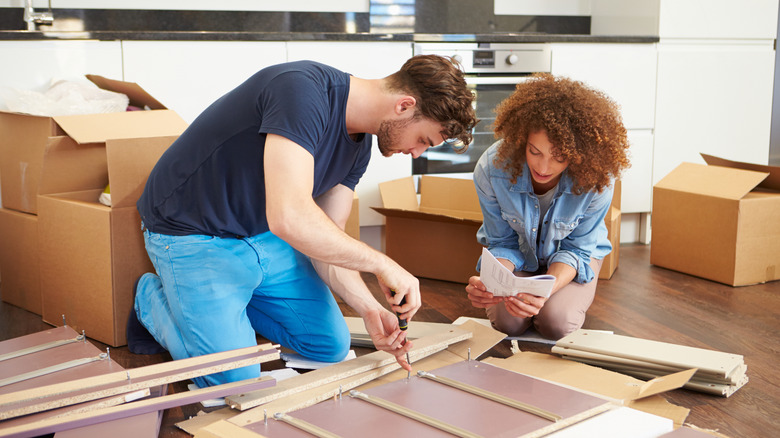 A couple assembling furniture in their home
