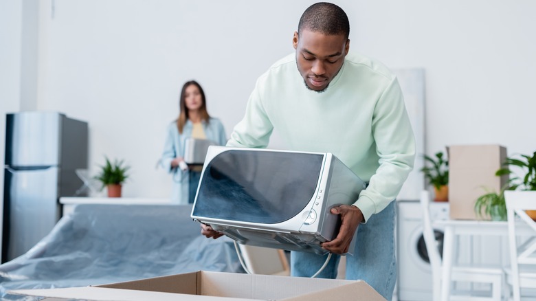 Man putting microwave in box