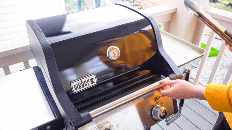 Person using a Weber gas grill