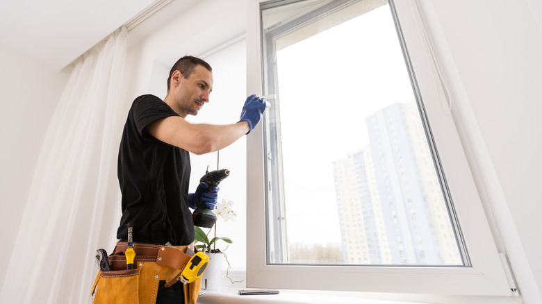 Contractor installing window in a house