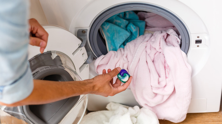 Person holding laundry pod 