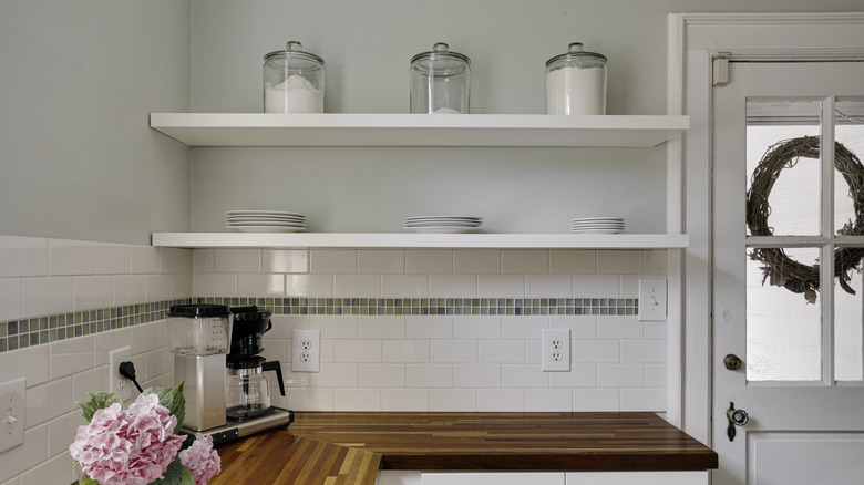 White kitchen with sparsely decorated open shelving