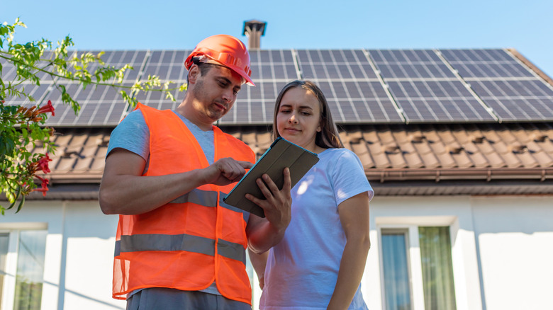 an Engineer and woman discussing solar panel installation
