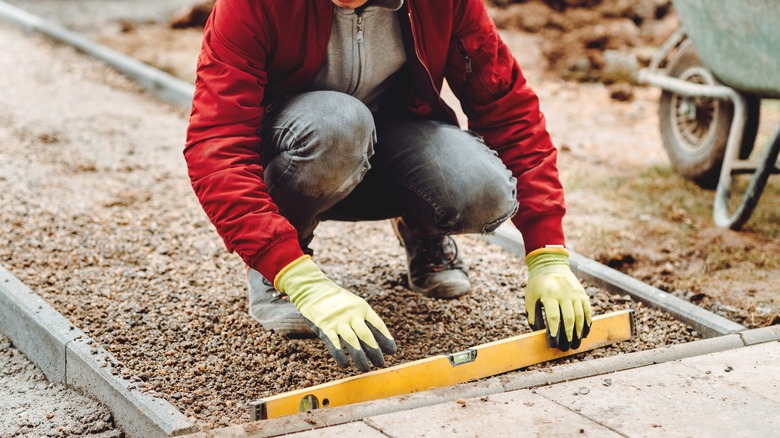 Worker uses level on sidewalk