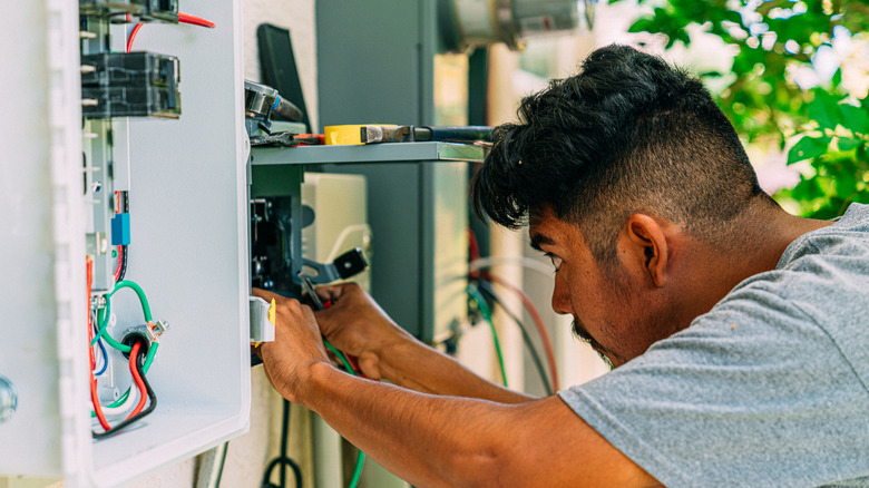 A professional looking at electrical wires