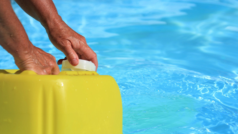 hands holding liquid chlorine container