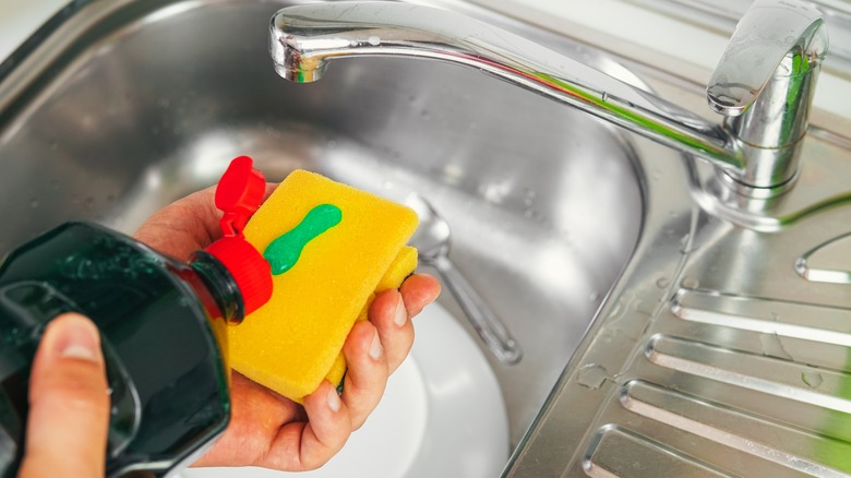 Hands squeezing soap onto sponge