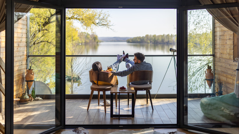 Couple sitting on deck outside of lake house