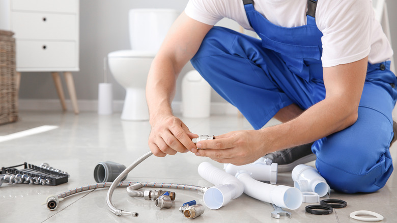 Worker with tools in bathroom
