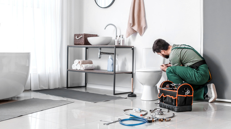 Worker installing bathroom toilet