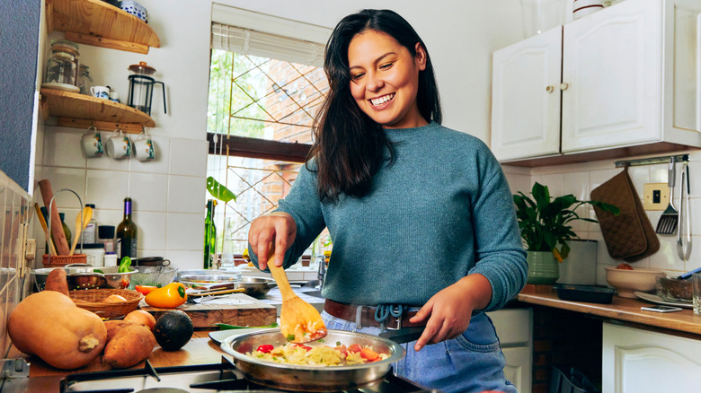 A woman cooks inside of a kitchen.