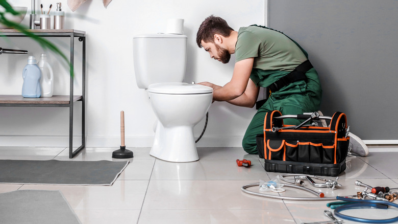 Plumber installing toilet