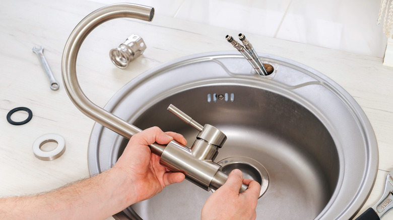 hand holding kitchen faucet