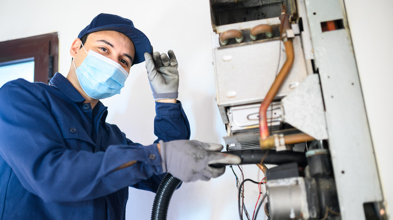 technician repairing water heater