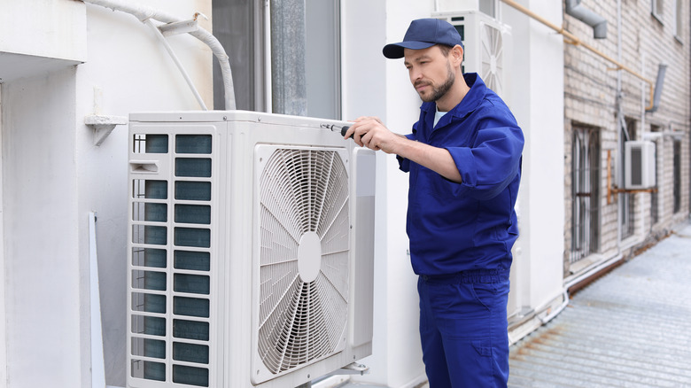 technician repairing air conditioning unit