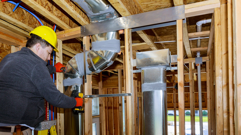 Person installing ducts in home