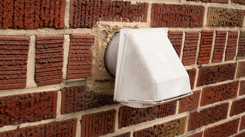 Dryer vent coming out of a brick exterior wall