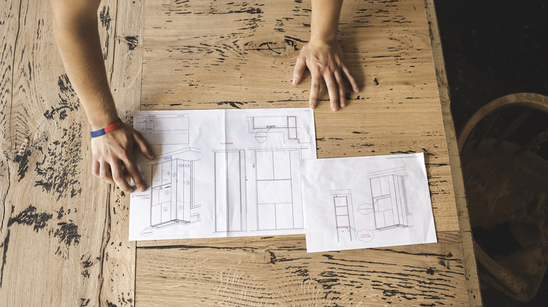 Someone working on a closet design on paper.