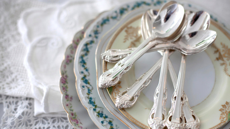 Silver spoons on a patterned plate on a table