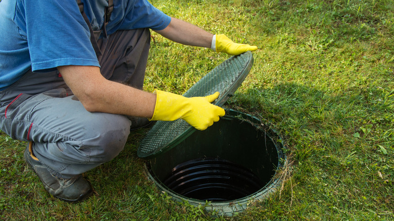 Person removing septic tank lid
