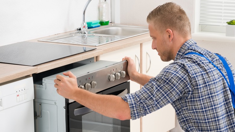 man installing oven in kitchen