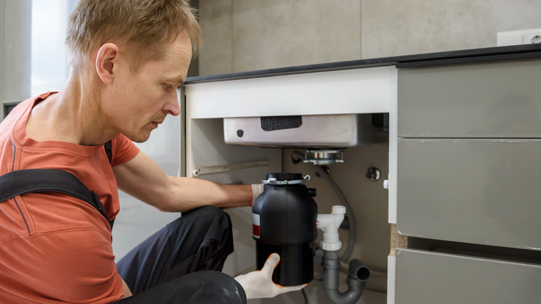 Man replacing garbage disposal