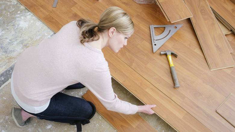 woman installing laminate planks