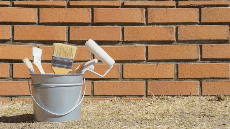 Brick wall with paint supplies in front of it
