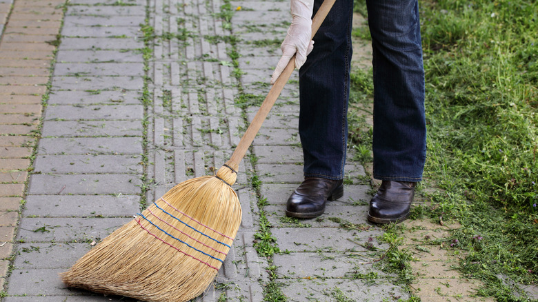 Using a broom on a sidewalk