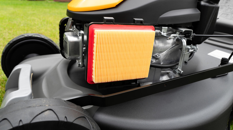 A new air filter located on a gas-powered push lawn mower.