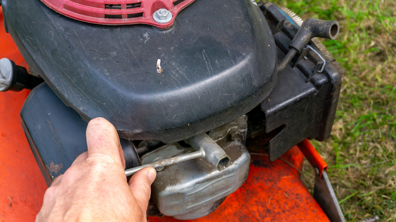 person maintenancing lawn mower