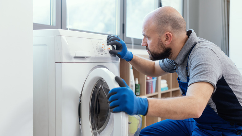 a washing machine technician checking the knobs on a washer