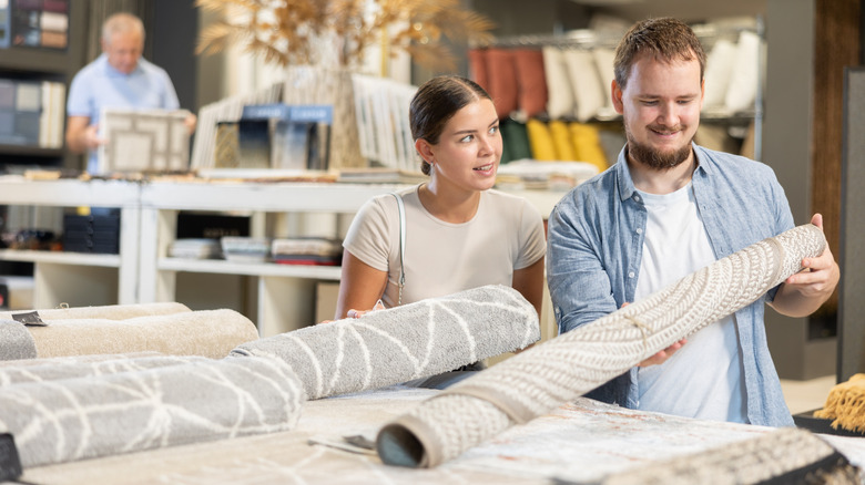 A couple is looking at carpet options in a store