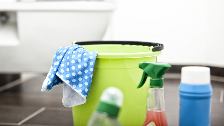 Close up of a bucket and cleaning products in a bathroom