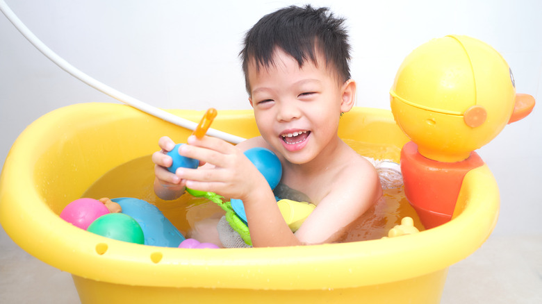 Boy playing with toys in bathtub