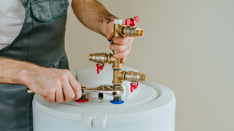 Technician in denim overalls installing a water heater