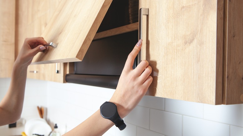 Person opening kitchen cabinets