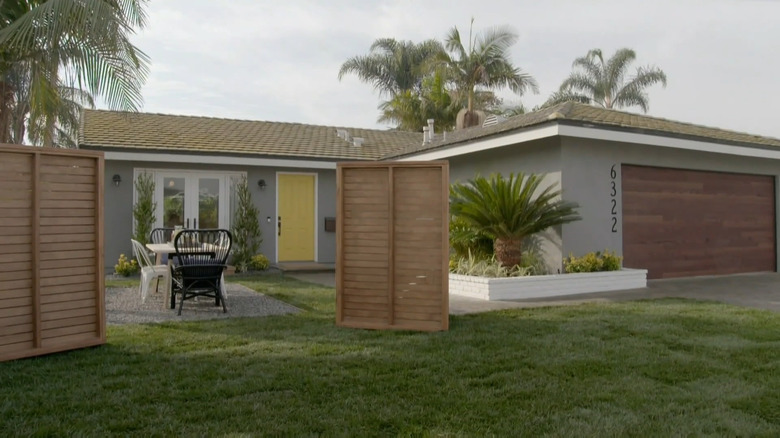 Wooden privacy screen in front yard of one story house