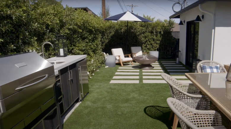Lush hedge around backyard with grill and outdoor seating