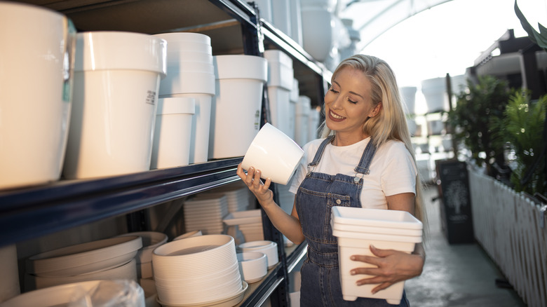 woman holds white plastic planters
