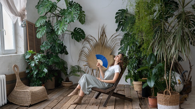 Woman relaxing among indoor plants