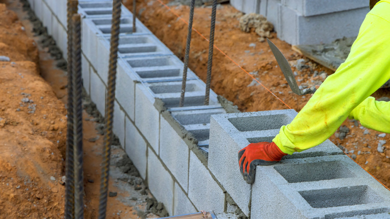 A cinder block wall with rebar used for house foundations