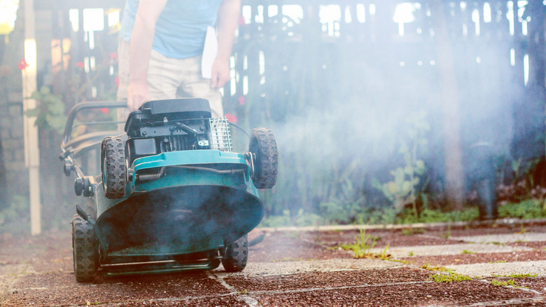 An old, smoking lawn mower