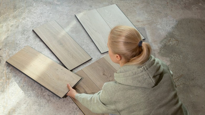 A woman looking at vinyl plank flooring samples
