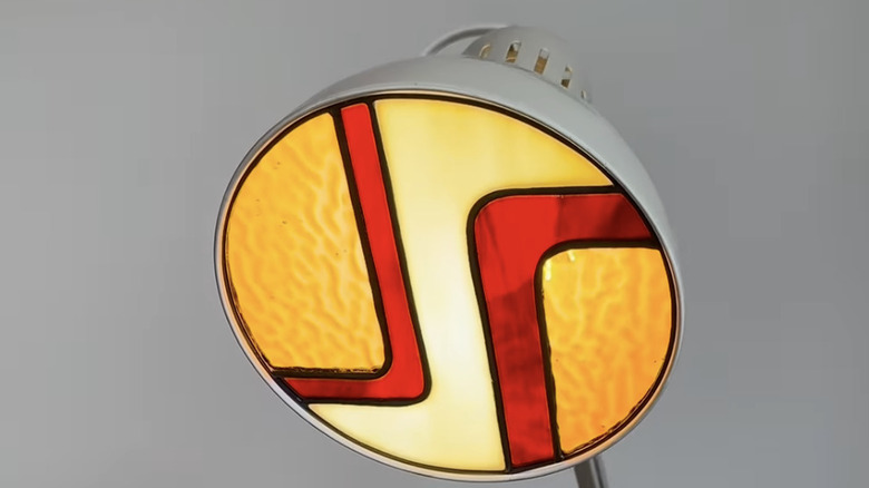 An IKEA TERTIAL work lamp with a stained glass insert.