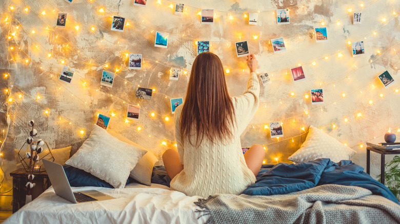 A woman hanging photographs on a wall