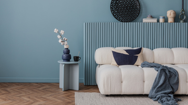 A white couch with a small side table