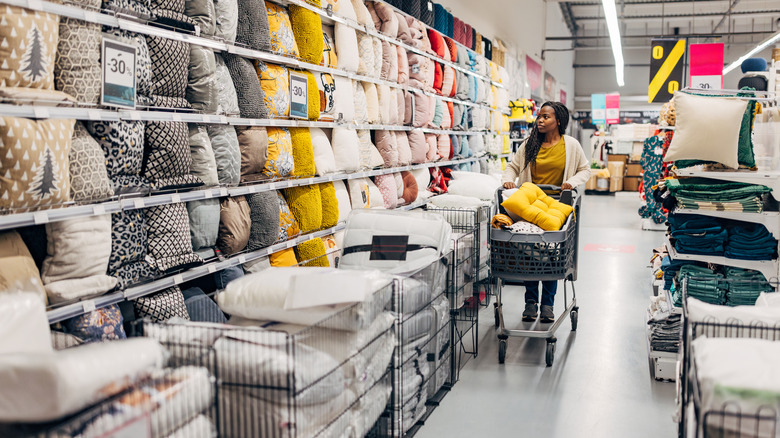 A woman shops in the bedding aisle of a home store