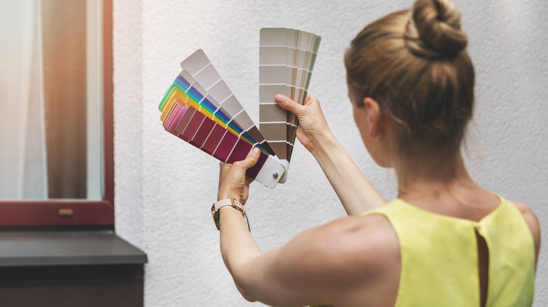 Woman looking at paint swatches to pick an exterior color for her home