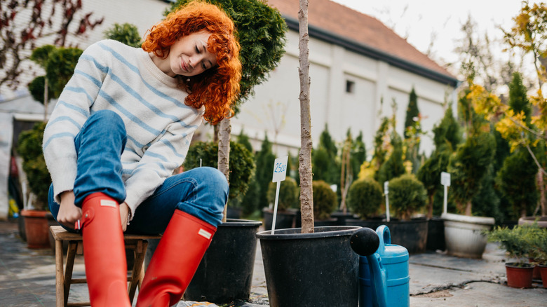 A person putting on rain boots to work in the garden